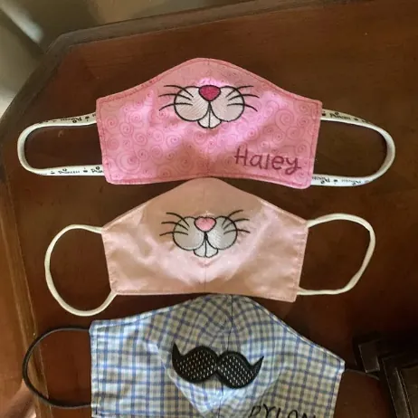 Personalized bunny face masks with embroidered nose and whiskers, one stitched with the name Haley