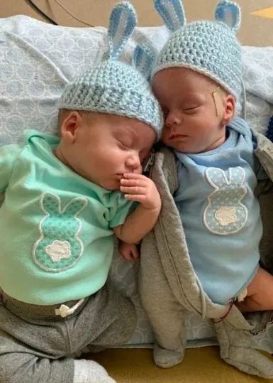 Twin babies wearing matching bunny silhouette applique shirts and crochet bunny hats