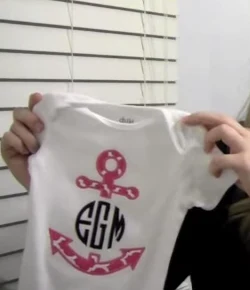 Finished onesie with a pink anchor applique frame and circle monogram