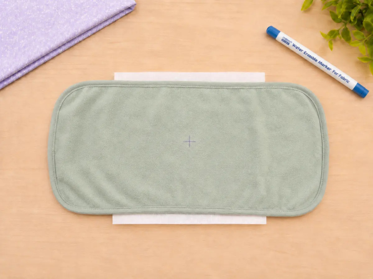 Mark the embroidery center and align it with the hoop marks before tightening.