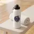 Distressed volleyball SVG cut in navy on a white insulated water bottle on a gym bench beside a rolled white towel